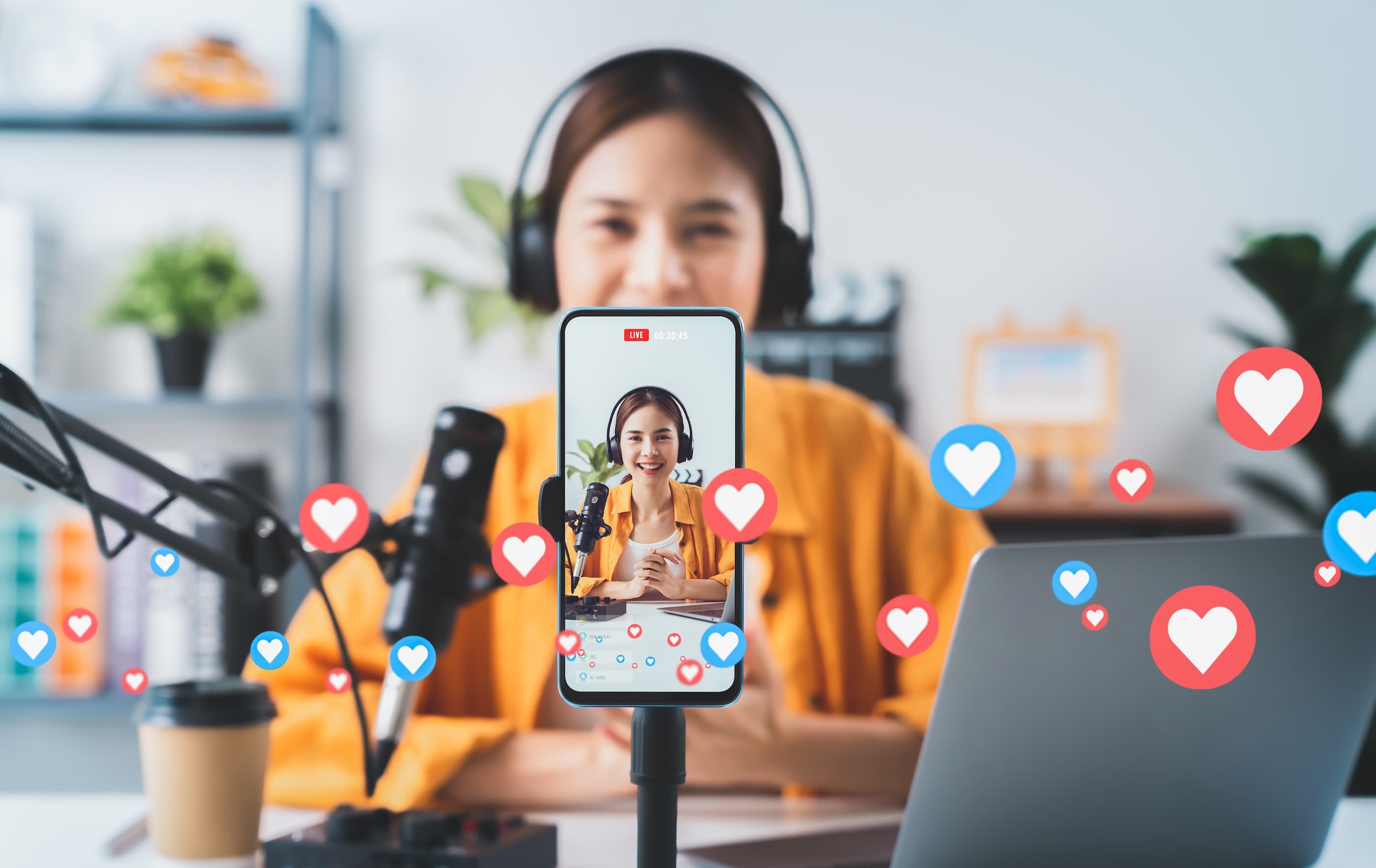A creator live-streaming a podcast review with hearts and reactions floating up — the specialist channels where B2B trust is built
